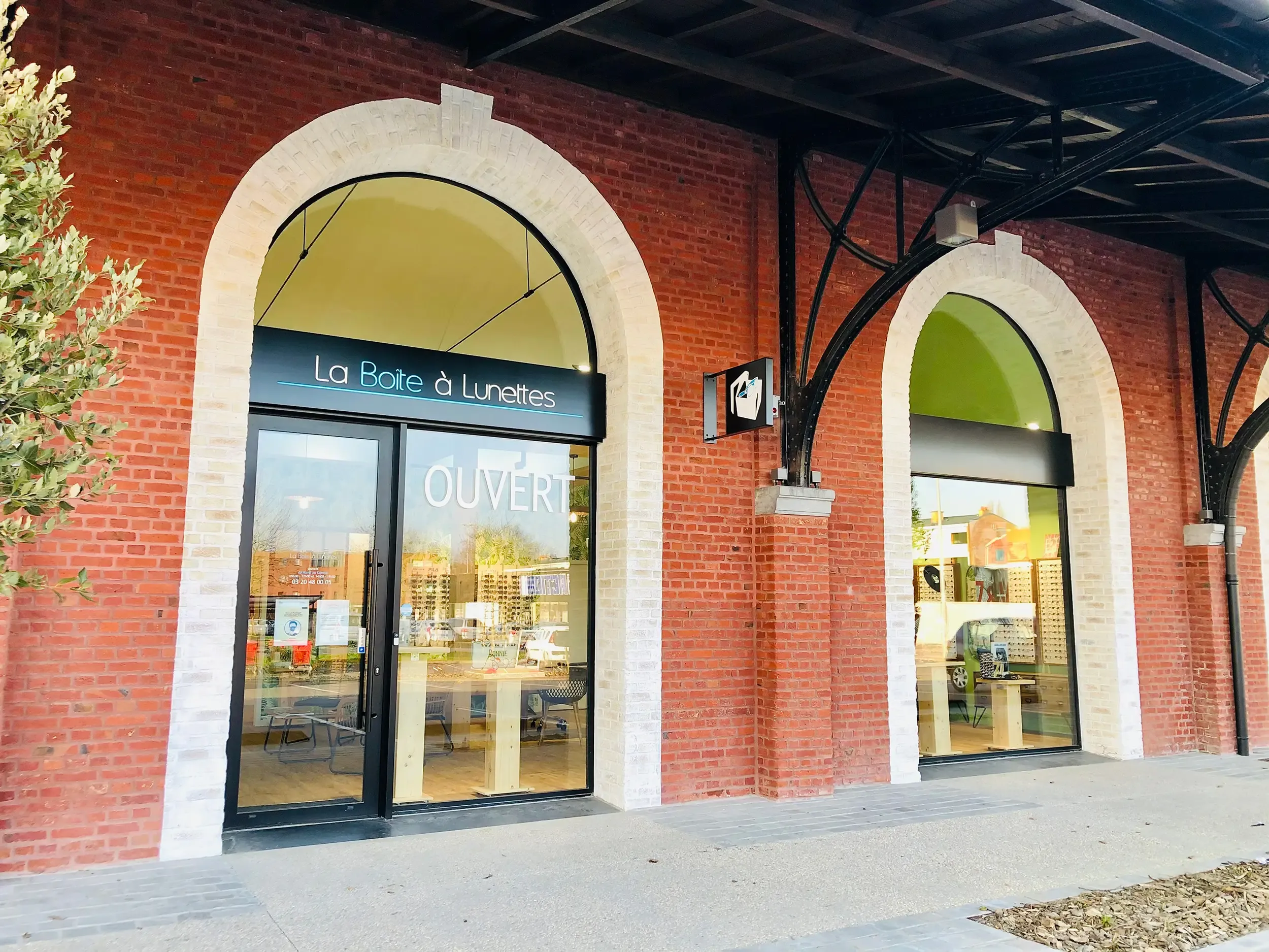 La devanture du magasin, sous les arches en briques de la zone commerciale